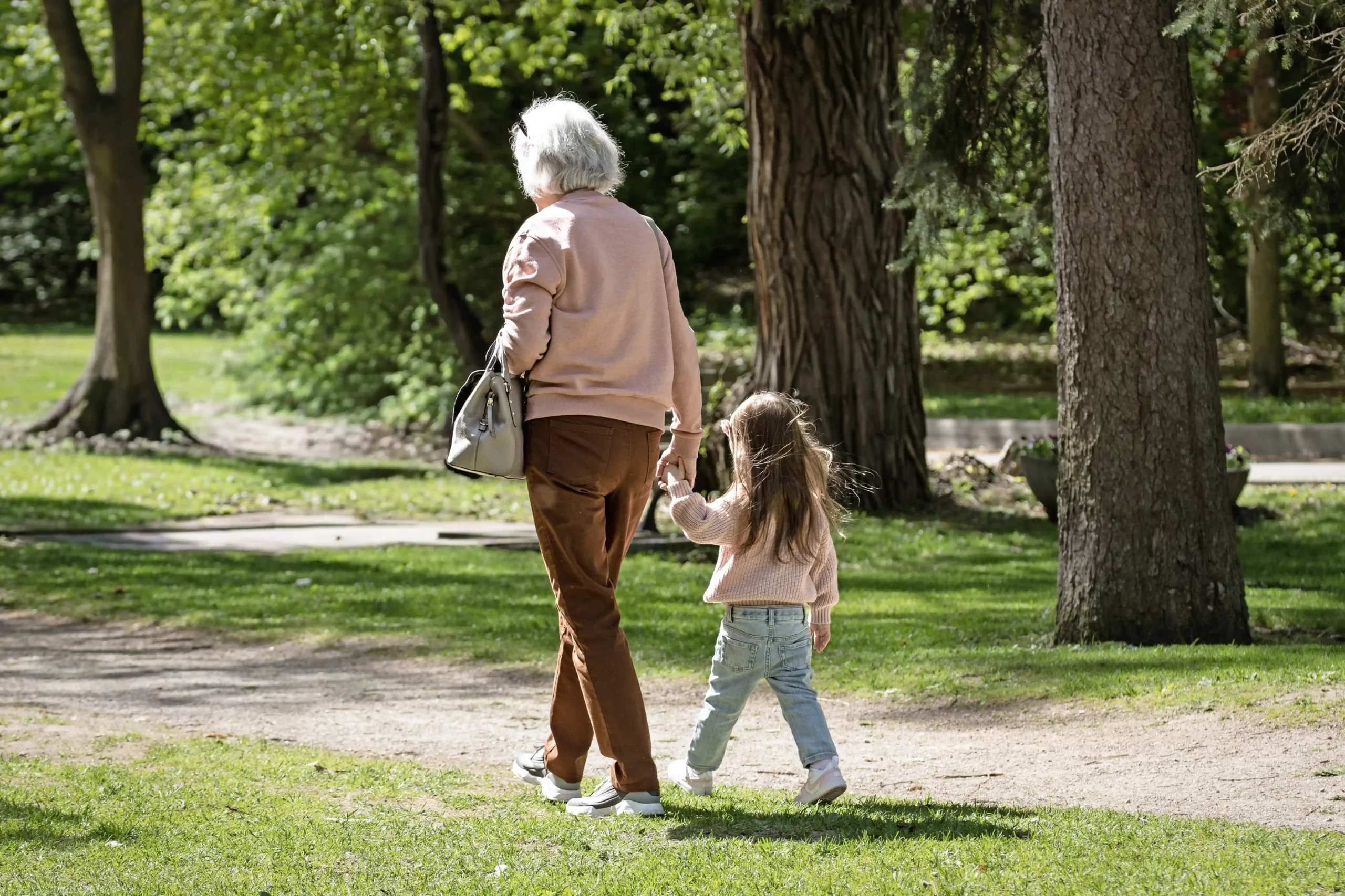 A woman and a child holding hands as a representation of children and youth therapy.